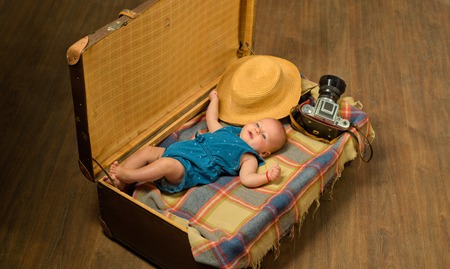 Soon you will be with us. Childhood happiness. Photo journalist. Sweet little baby. New life and birth. Family. Child care. Small girl in suitcase. Traveling and adventure. Family vacation.の写真素材