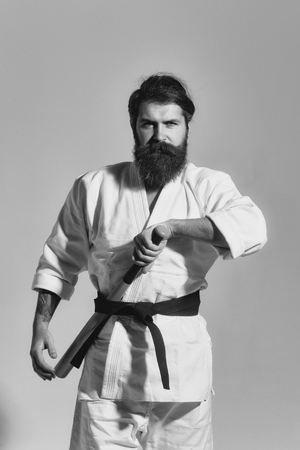 bearded serious karate man in kimono with green baseball batの写真素材