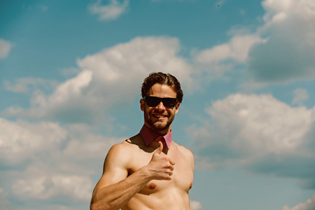 Like concept. Happy man show thumbs up like on cloudy sky. Topless guy smile with like gesture outdoor. Hand likeの写真素材