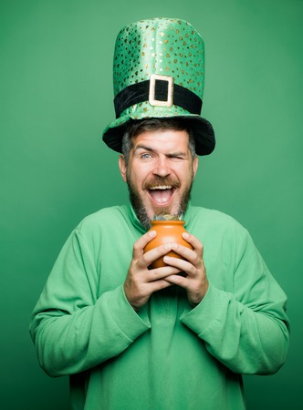 Happy St Patricks Day concept with pot of gold. Man on green background celebrate St Patricks Day....
