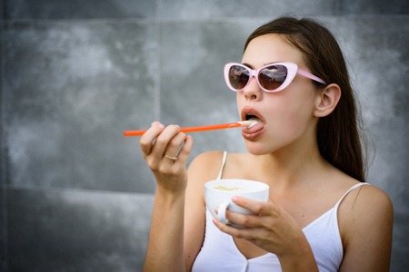 Taste the freshness. Fashionable woman enjoy sipping drink through straw. Pretty woman sip beverage with drinking straw. Cute woman drink through straw in cafe. Smooth out your day everyday.の写真素材