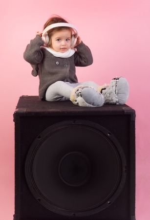 childhood and happiness. kid listen music with headset and mp3 on phone. small happy girl. audio speaker. little girl child smiling. winter kid fashion. having fun. Perfect song. She got great style.の写真素材