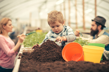 little farmer. little farmer work with soil. little farmer in greenhouse. little farmer child planting flowersの写真素材