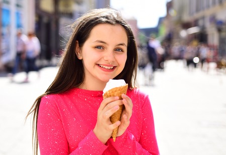Pure and sweet cream. Pretty girl hold ice cream cone on summer day. Cute girl smiling with ice cream. Happy girl child eating ice cream in hot weather. Enjoying frozen food snack or dessert.の写真素材