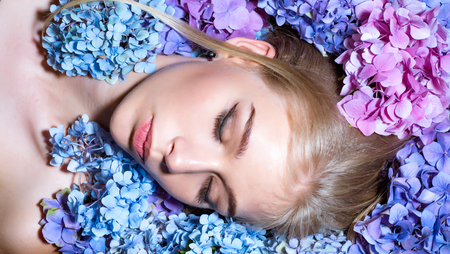 Summer beauty. girl with summer makeup. Makeup cosmetics and skincare. Spring woman with hydrangea flowers. Fashion portrait of woman. Healthy hair and skin. Enjoying springtime.の写真素材