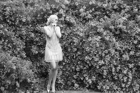 Pretty woman near rose bush