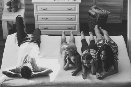 Man, woman and adorable kids watching tv in apartmentの写真素材