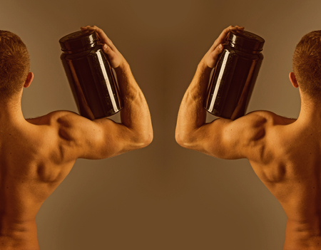 Maintaining optimal health and wellbeing. Bodybuilding sport and fitness. Vitamin diet and sport nutrition. Strong men hold supplement bottles. Fit men with vitamin supplements. Eat a healthy dietの写真素材