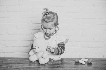 Boy play doctor with teddy bear on white wallの写真素材
