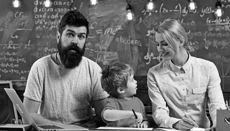 Little child study painting with woman and man. Family paint in felt pens on paper. Son with mother and father sit at desk. Enjoy drawing together. Creativity and developmentの写真素材