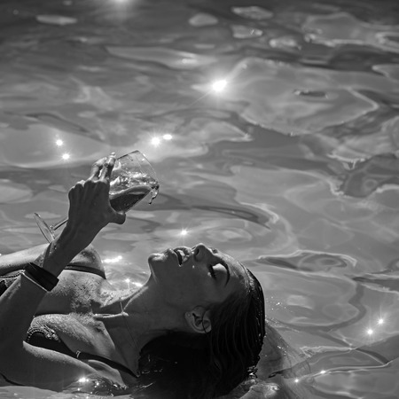 girl holding cocktail on the sea background. It looks coolの写真素材