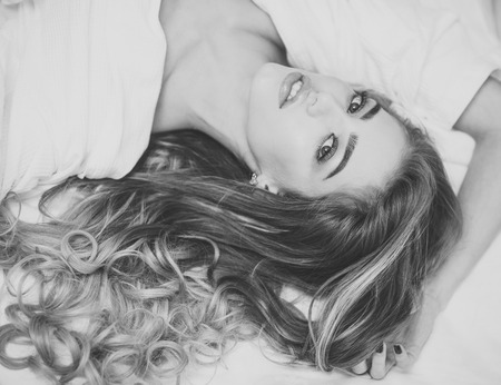 Lady with make up relaxing on bed, top view.の写真素材