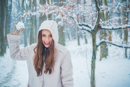 Winter portrait of young beautiful brunette woman in snow Garden. People in snow. Woman winter portrait.の写真素材