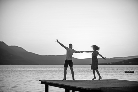 girl and man dance at sea water in sunset. girl and man dancing in twilight.の写真素材
