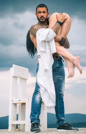 Latino handsome man and sexy woman. Man is carrying his woman. Love. Couple.の写真素材
