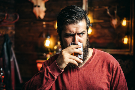 Man with alcohol drink at home. Drinking man. Barman hipster. Alcohol addiction.の写真素材