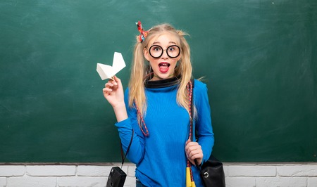 Fashionable blonde girl chalkboard background. Back to school. Stylish school pupil modern girl. Cute female funky style. Enjoying her school life. Fancy schoolgirl. School fashion. Carefree teenagerの写真素材