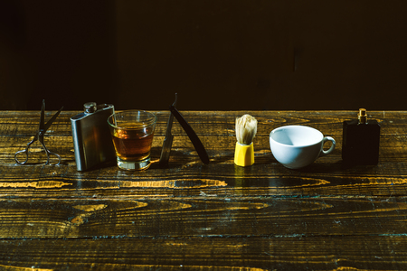 Barber making haircut of attractive bearded man in barber shop. Shaving man and razor man. Vintage barber shop shaving. Moustache Wax. Senior man visiting hairstylist in barbershop.の写真素材