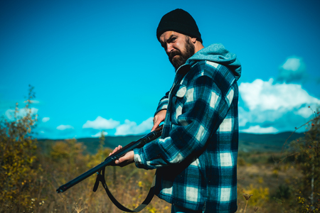 Hunter with shotgun gun on hunt. Hunting without borders. Clothes for the hunter. Close up Portrait of hamdsome Hunter.の写真素材