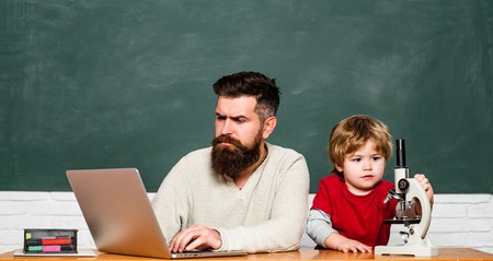 Happy family. Daddy and his little son. Tutoring. Daddy Teacher. Childhood and parenthood. Elementary school kid and teacher in classroom at school.の写真素材
