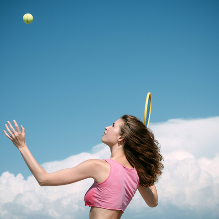 Improving her tennis game. Sexy athletic woman playing tennis game outdoor. Fit tennis player hitting a shot during the game. Sensual girl as good as her sport gameの写真素材