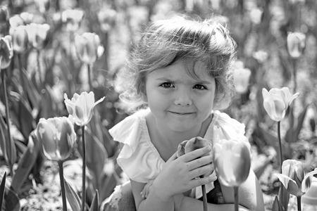 Little girl in sunny spring. Summer girl fashion. Happy childhood. face and skincare. allergy to flower. Springtime tulips. weather forecast. Small child. Natural beauty. Childrens day. Forever young.の写真素材