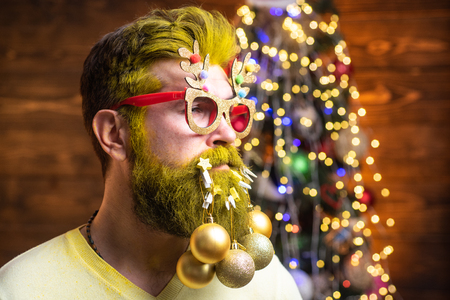 Bearded modern Santa Claus in knitted sweater. New year concept. Styling Santa hipster with a long beard posing on the Christmas wooden background.の写真素材