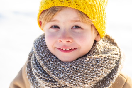Snow games. Winter holidays concept. Have wonderful holiday. Happy new year and merry christmas. Happy winter child snow background. Cute boy in winter clothes hat and scarf close up. Winter fashionの写真素材