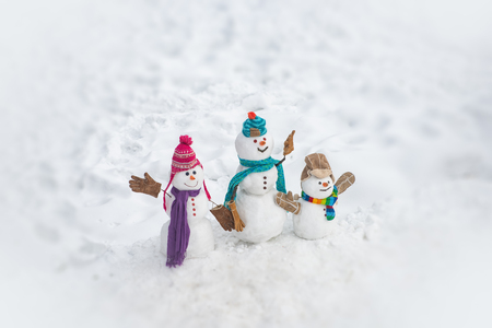 Happy winter snowman family. Mother snow-woman, father snow-man and kid wishes merry Christmas and Happy New Year. Merry Christmas and happy New Year greeting card with copy-space.の写真素材