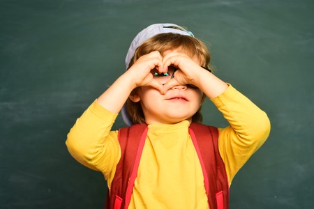 Kid is learning in class on background of blackboard. Talented child. September 1. Education. Boy from elementary school at the school yardの写真素材