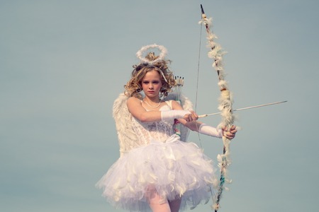 St Valentines day. little Cupid girl aiming at someone with an arrow of love. Innocent girl....