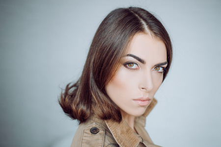 Attractive girl with perfect skin. Makeup, smooth skin. Beauty woman in studio on gray background. Close-up portrait.の写真素材