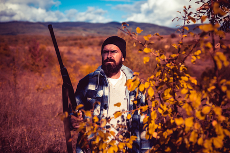 Autumn hunting season. Hunter with shotgun gun on hunt. Autunm hunting. Hunting in America. Mountain hunting.の写真素材