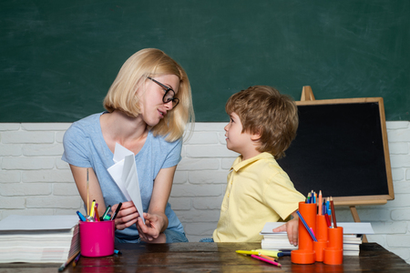 Back to school. Child and teacher near chalkboard in school classroom. Great study achievement. School lessons.の写真素材