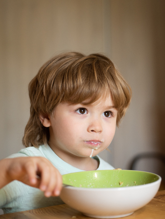 Happy child. The child in the kitchen at the table eating. Little baby are eating. Good morning in Happy family. Summer ration.の写真素材