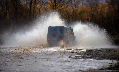 Off road. Suv splash on the river outdoor, traveling on the road. cene of mud splash in off-road racing. Stop action with high speed shutter.の写真素材