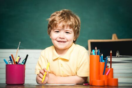 Home or school education. Portrait child from elementary school. Boy pupil from elementary school at the school yard. Cheerful smiling child at the blackboard.の写真素材