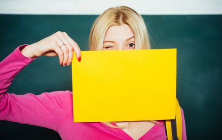 Student ready to school an educational. Happy teen college studying. Caucasian female student laughing, preparing university creative research project, showing yellow notebook for copy space text.の写真素材