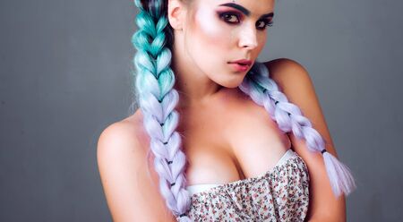 Eyes flash fire. Headshot photo of elegant European female model with colorful makeup and pigtails....