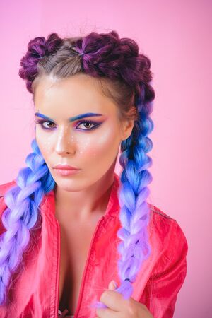 Colorful makeup and pigtails. Fashion photo of gorgeous European female model with art design. Eyes...