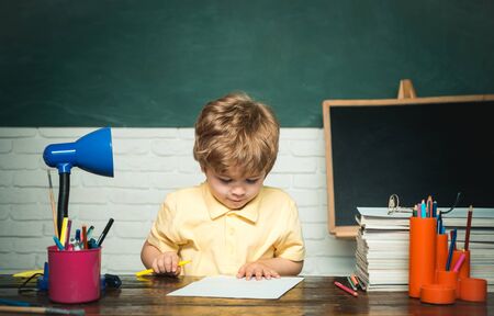 Home or school education. Portrait child from elementary school. Boy pupil from elementary school at the school yard. Chalkboard copy space.の写真素材