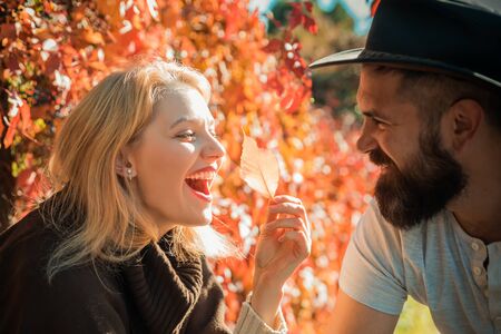 Autumn couple. Happy smiling attractive young couple on date sitting in street cafe in autumn, sharing drink, looking at each other with love, flirting, having fun together.の写真素材
