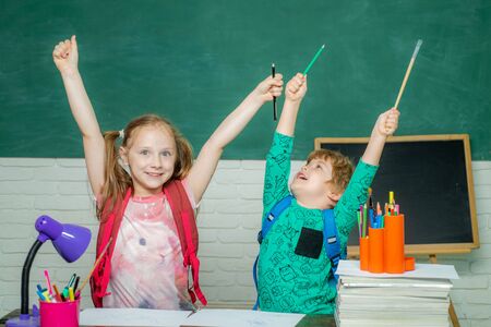 Back to school and happy time. Child is ready to answer with a blackboard on a background.