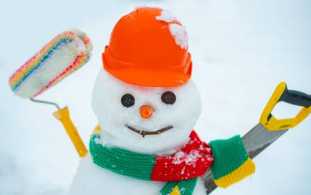 Winter scene with snowman builder on white snow background. Handmade snowman builder in the snow outdoor. Winter Art Greeting Card for builders.の写真素材