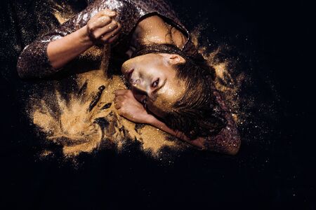 Vogue and glamour concept. Golden skin. Attractive woman pretty face with makeup and body art metallized color. Spa and wellness. Golden mask. Luxury beauty procedure. Pure gold. Golden lady relaxingの写真素材