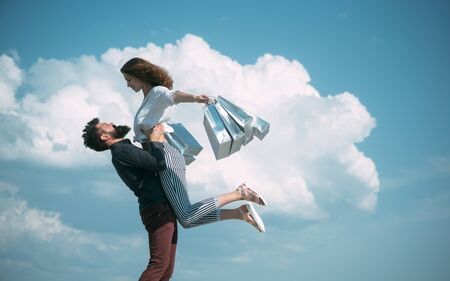 sense of freedom. couple in love. present packages. family holiday. summer fashion. spring. bearded man with happy woman hold shopping bag. successful shopping. Fitting you perfectlyの写真素材
