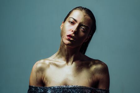 Attractive woman pretty face with makeup and body art metallized color. Spa and wellness. Golden mask. Luxury beauty procedure. Pure gold. Golden lady fashion model. Vogue concept. Golden skinの写真素材