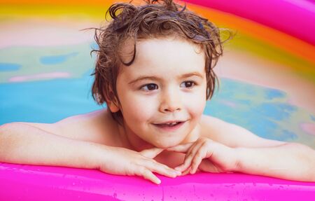 Little girl having fun in swimming-pool. Happy child having fun at swimming pool on sunny day. Children playing in pool. Kids Swimming Pool Concept.の写真素材