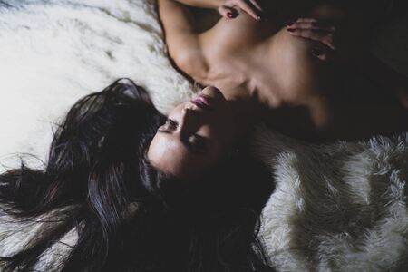 Female breasts smooth skin. Sexy girl sexual stimulation nipples. Erotic massage. Perfect breasts. Waiting for you. Orgasm and foreplay. Sexy attractive seductress. Sexy woman relaxing on fluffy bedの写真素材