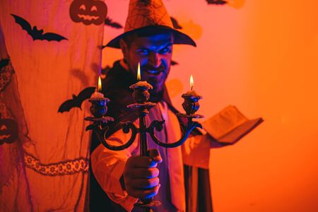 Halloween man with pumpkin in darkness. Happy hipster with bloody beard with pumpkins. Halloween, holidays celebration.の写真素材